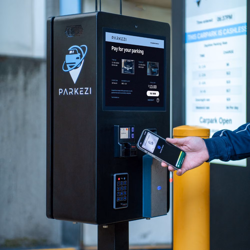 Driver using contactless payment at a Parkezi terminal during system testing.