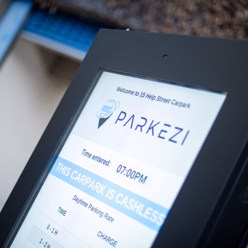 Parkezi info board displaying site rules and parking rates.
